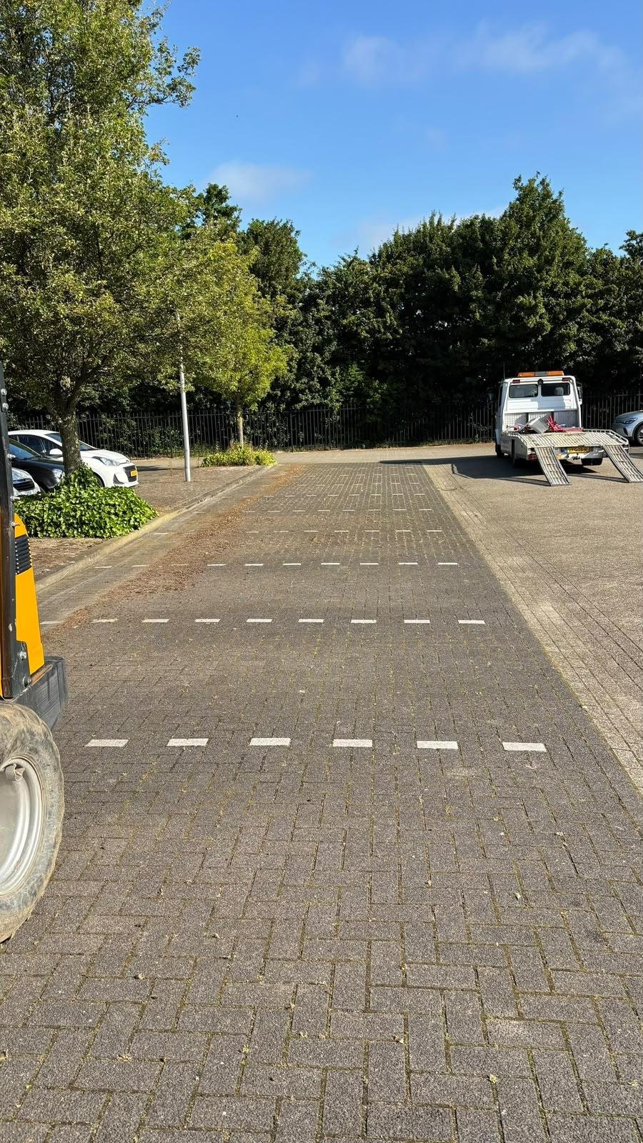 Mechanisch onkruid verwijderen en vegen van een parkeerplaats zonder chemische bestrijdingsmiddelen